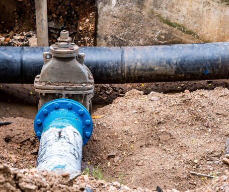 A water meter and pipes installed by a drainage contractor in the ground.
