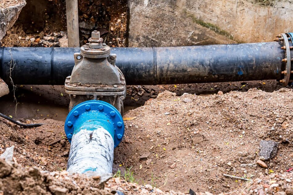 A water meter and pipes installed by a drainage contractor in the ground.