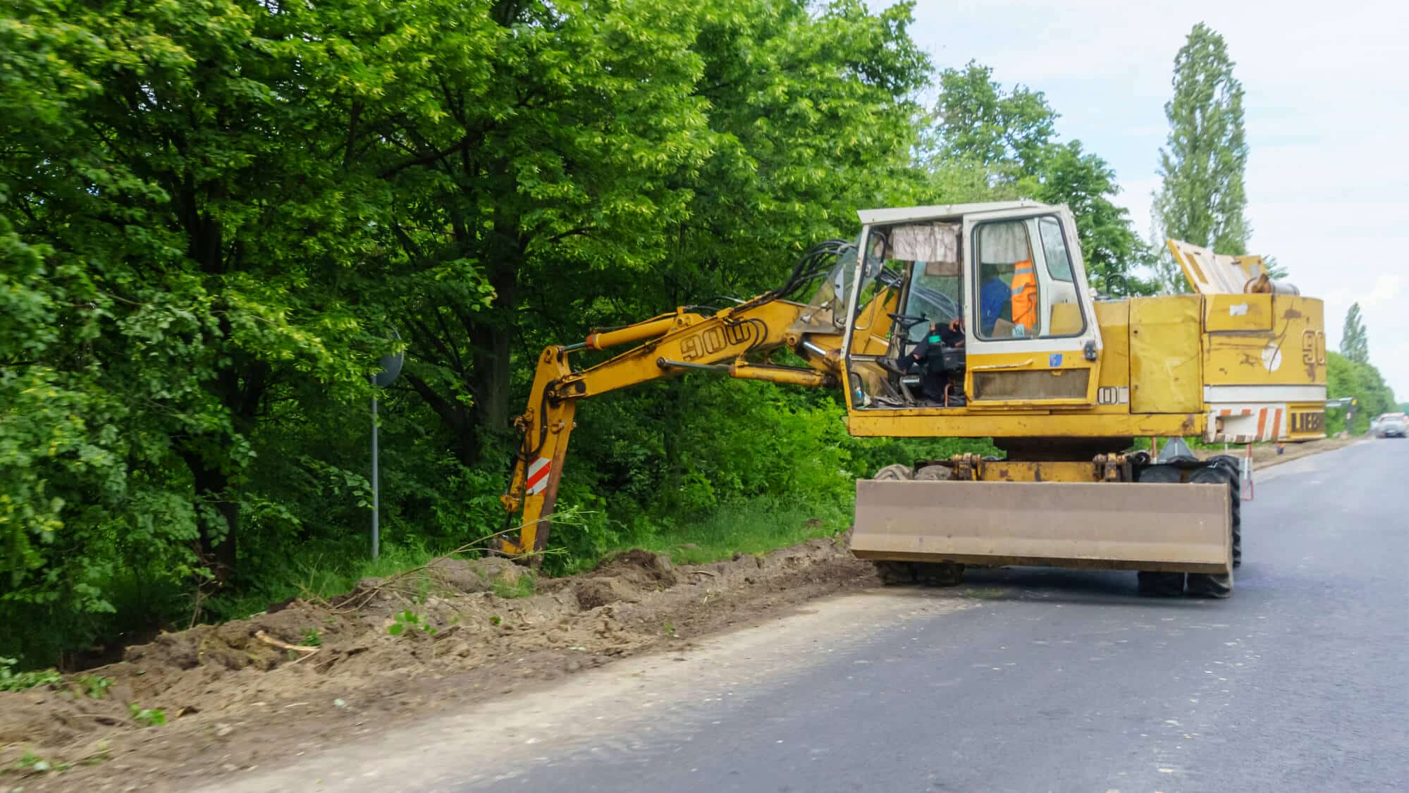 Excavator Digging on Sidewalk - Big Easy Drainage